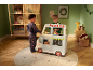 Kinder spielen mit einem hölzernen Spielzeug-Foodtruck in einem festlich dekorierten Raum.