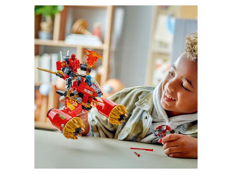 Ein lächelndes Kind spielt mit einem roten LEGO Ninjago Set, einem großen Roboter und einer kleinen Minifigur.