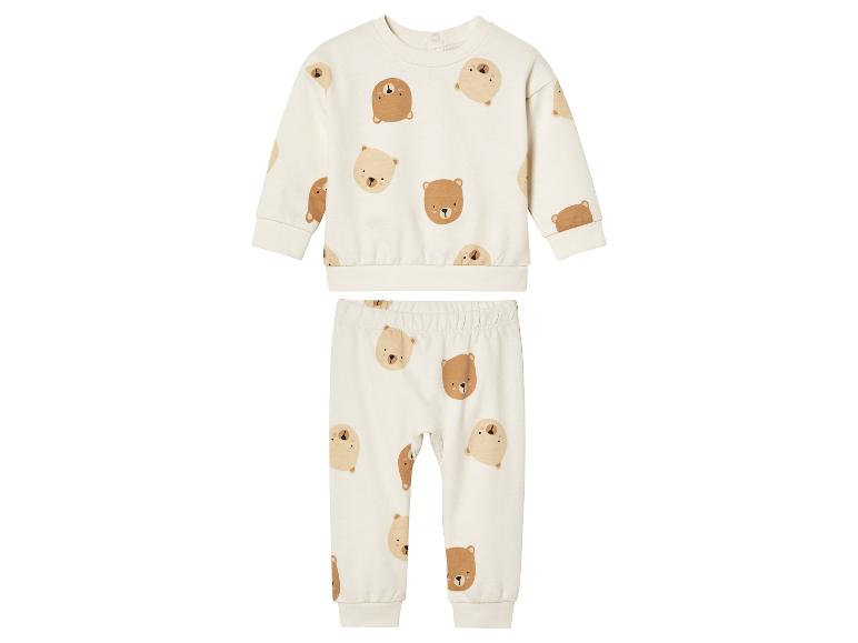 Ein weißer Baby-Anzug mit beigefarbenem Pullover und Hose mit Bären-Print.