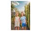 Mädchen in Zitronenkleid und Junge in Dinosaurier-T-Shirt und blauen Shorts.
