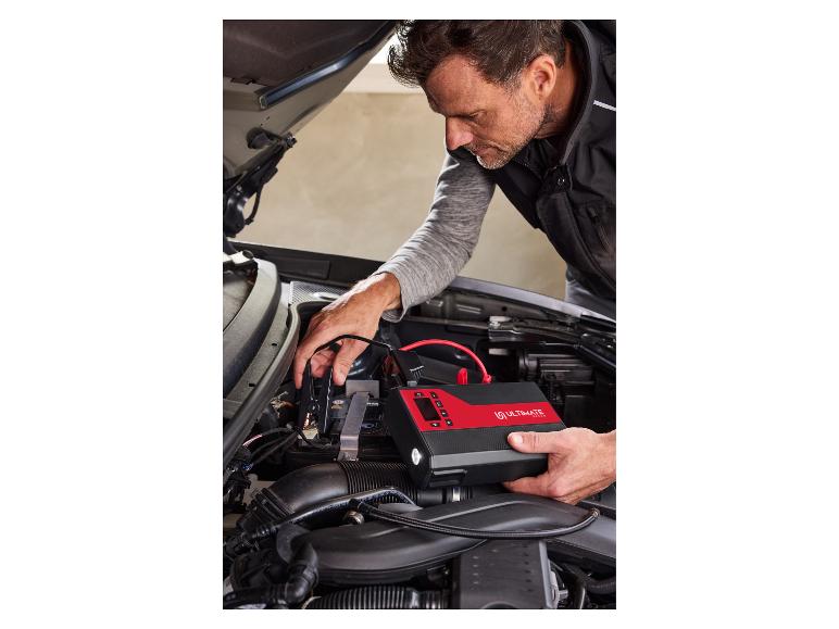 Mann benutzt ein Ultimate Speed Starthilfegerät im Motorraum eines Autos.