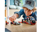 Junge spielt mit einem Spielzeug-Rennwagentransporter und einem Rennwagen.