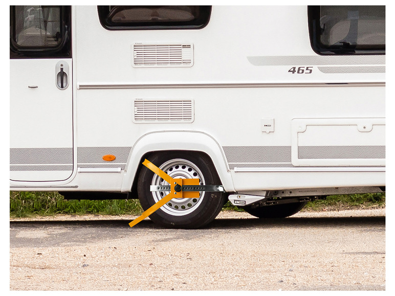 Ein weißer Wohnwagen mit einem Radklemmschutz