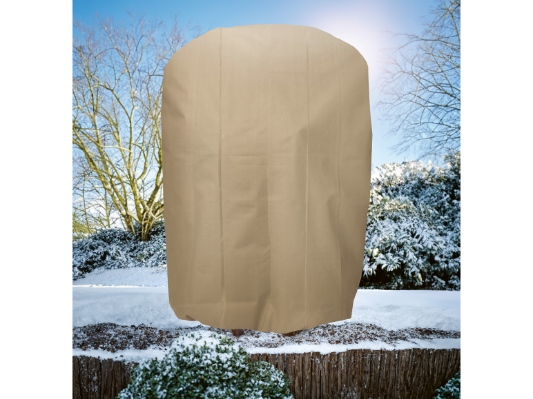 Beige Pflanzenschutzhülle in einer verschneiten Winterlandschaft.