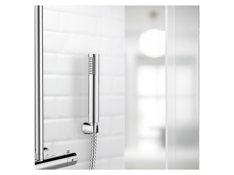 Chrom-Duschgarnitur mit Handbrause, an einer weißen gefliesten Wand montiert.