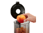 Hand legt Apfel in transparenten Behälter mit Deckel.