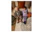 Zwei Kinder in gemütlichen Halloween-Pyjamas sitzen auf dem Boden vor einem Sofa