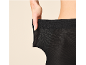 Frau dehnt den Bund einer schwarzen Strumpfhose, zeigt die Elastizität.