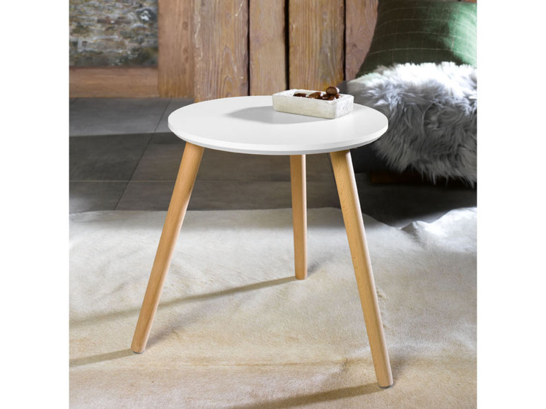 Ein weißer Couchtisch mit Holzbeinen.