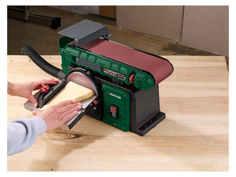 Eine Parkside Bandschleifmaschine mit Schleifband und Schleifscheibe, wird verwendet, um Holz zu schleifen.