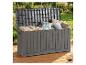 Graue Outdoor-Aufbewahrungsbox mit Kissen und Decken auf einer Holzterrasse im Garten.