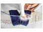 Draufsicht auf eine Person, die Jeans mit einem Bügeleisen bügelt.