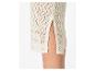 Detail eines cremefarbenen Strickrockes mit Lochmuster und seitlichem Schlitz.