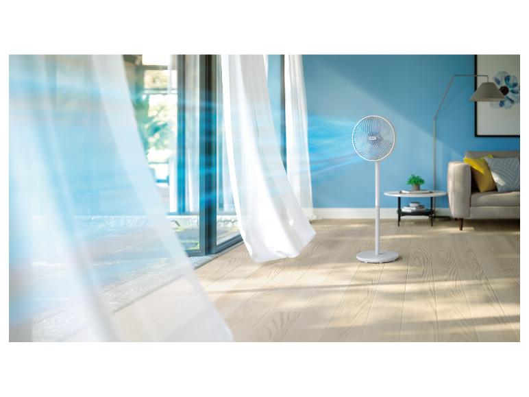 Weißer Ventilator in einem Raum mit blauen Wänden und hellen Vorhängen