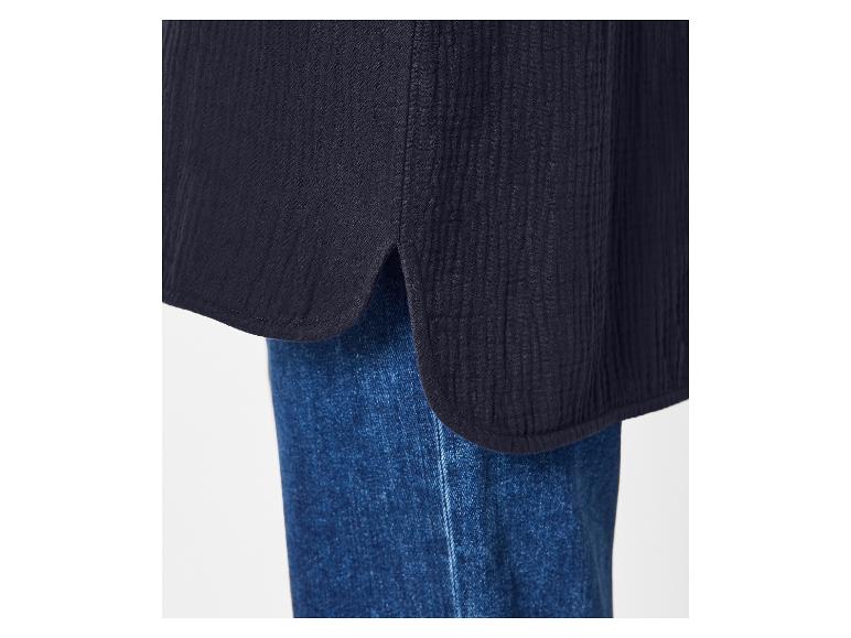 Nahaufnahme einer dunkelblauen Bluse mit abgerundetem Saum und Schlitz, über Jeans getragen.