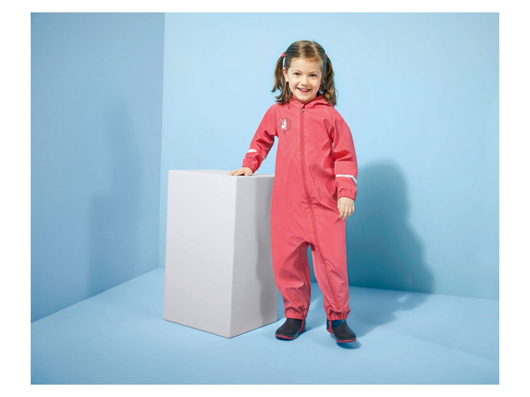 Ein Kind trägt einen rosafarbenen Regenoverall und Stiefel.