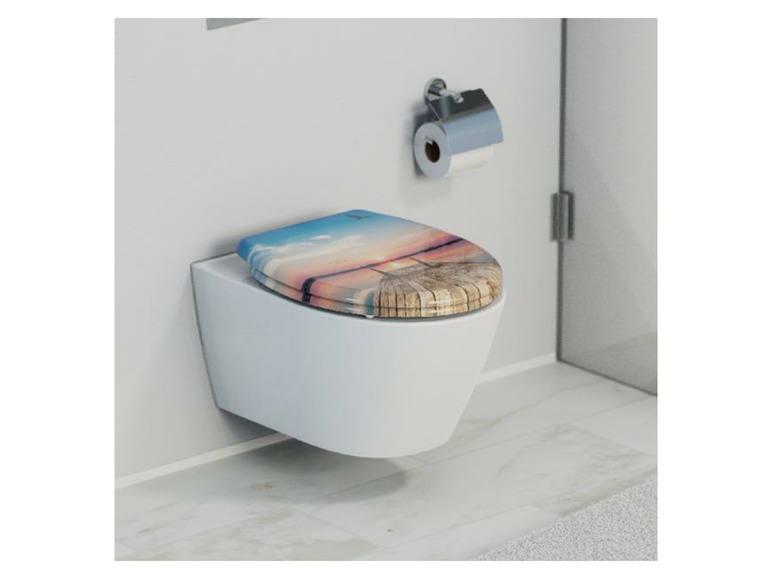 Ein Toilettensitz mit einem Druck eines Sonnenuntergangs über dem Wasser.