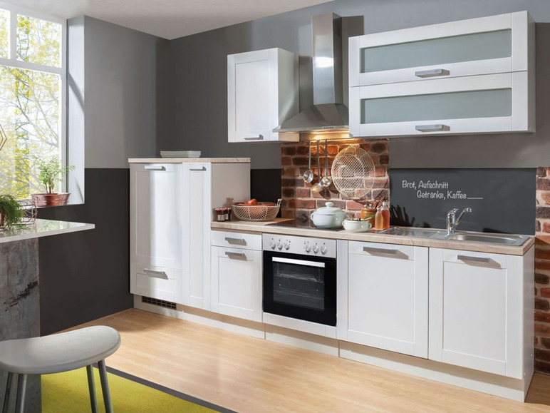 Weiße Küche mit Backofen, Spüle und Schränken.