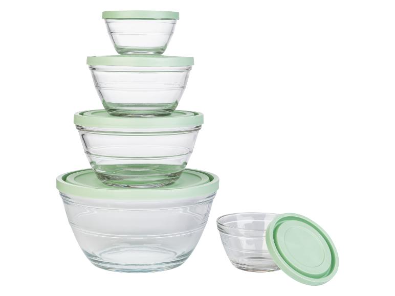 Eine Reihe von Glasschalen mit grünen Deckeln.
