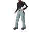 Frau in schwarzem Pullover, grauer Skihose und weißem Helm