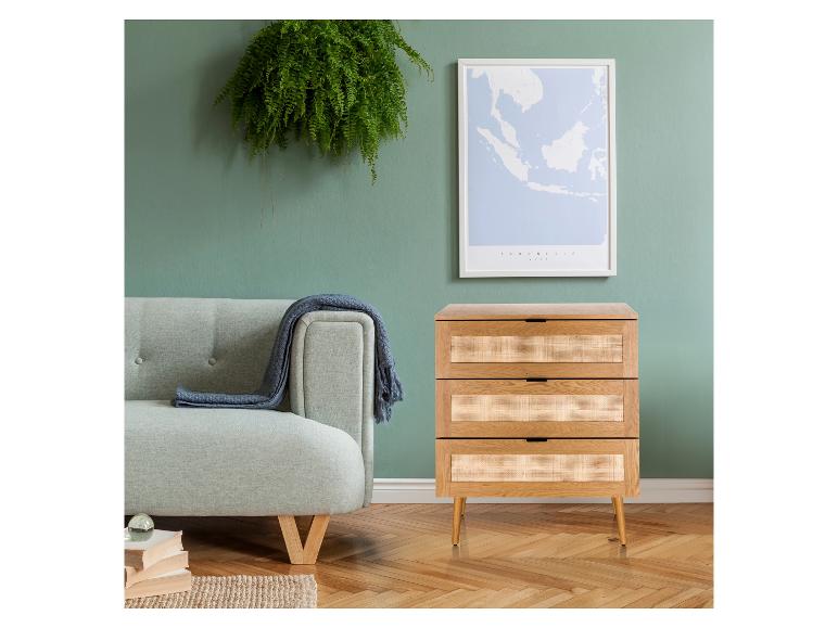 Wohnzimmer mit grüner Wand, Sofa, Rattan-Kommode und gerahmter Karte.