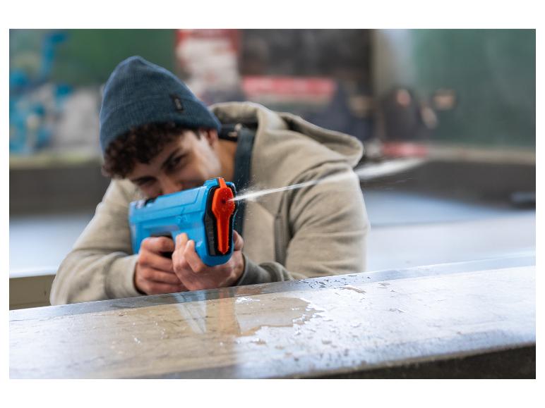Ein junger Mann spielt mit einer blauen Wasserpistole.