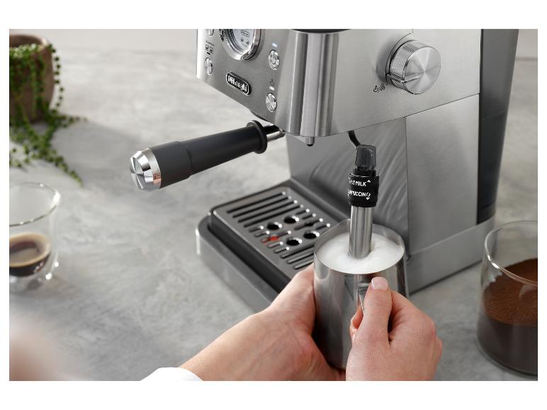 Eine Person bereitet Kaffee mit einem Milchaufschäumer an einer De'Longhi Kaffeemaschine zu.