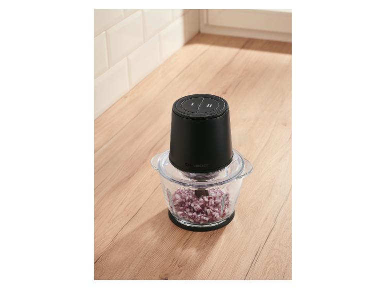 Zerkleinerer mit gewürfelten roten Zwiebeln auf einer Küchenarbeitsplatte aus Holz.