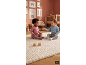 Zwei Babys sitzen auf einem Teppich und spielen mit Holzklötzen im Kinderzimmer.