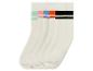 Vier Paar weiße Socken mit bunten Streifen.