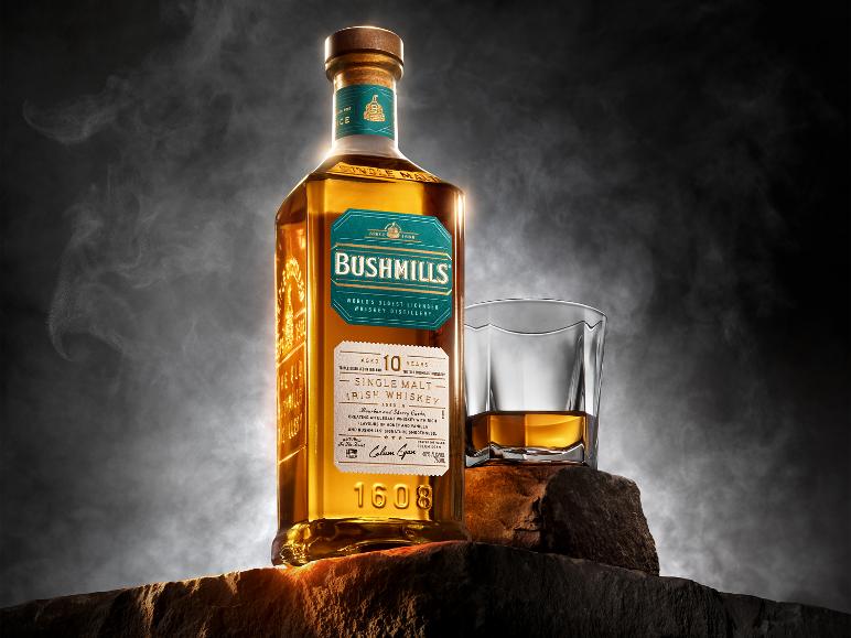 Flasche 10 Jahre alten irischen Single Malt Whiskys und Glas auf Felsen.