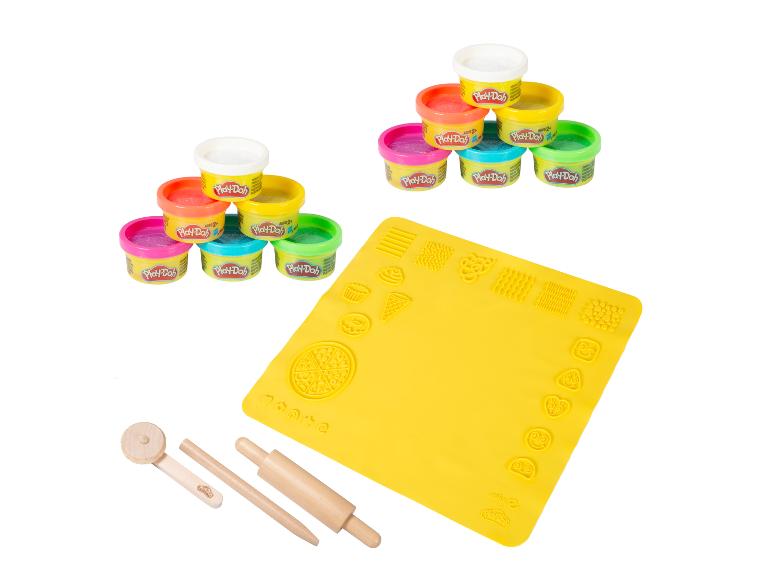 Bunte Knetmasse-Töpfe, eine gelbe Spielmatte mit Formen und Holzwerkzeuge.