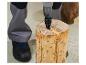 Person, die einen Bohrer zum Spalten eines Holzscheits mit einem Holzspalter verwendet.