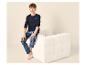 Jungen-Pyjama mit marineblauem Langarmshirt und blauer Karohose, sitzend auf einem weißen Sofa.