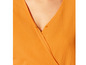 Detail einer orangefarbenen Bluse mit Knöpfen.