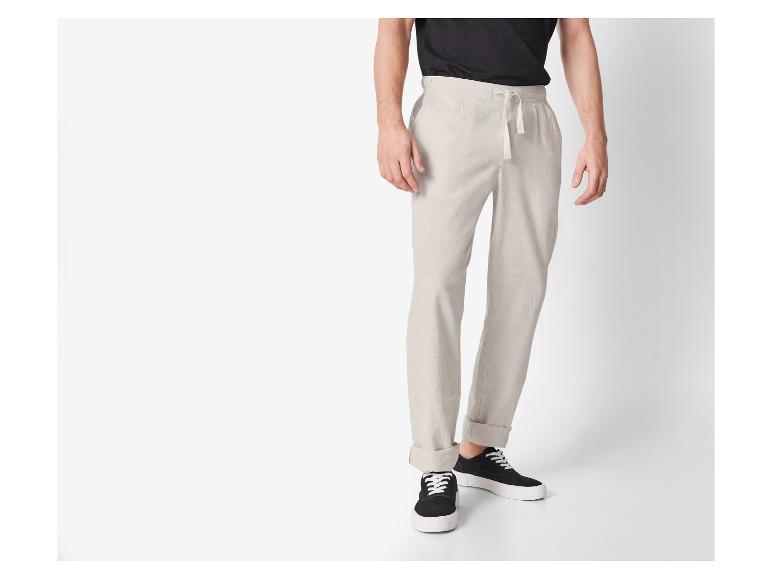 Beige Leinenhose und schwarze Sneaker: lässiger Look.