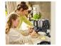 Mutter und Tochter kochen mit einer Küchenmaschine, schlagen Eier in eine Schüssel.
