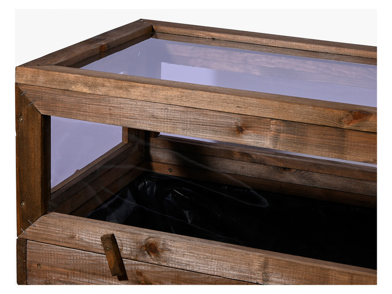 Ein hölzerner Pflanzenkasten mit Glasdeckel.