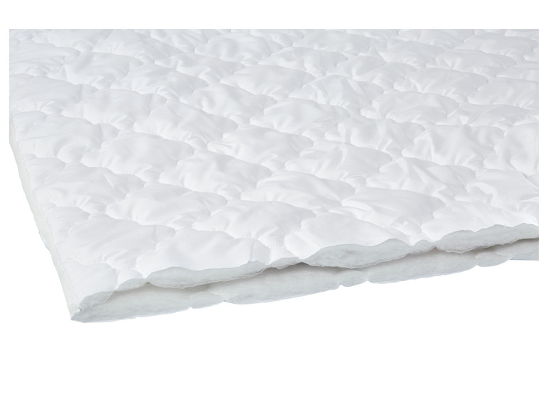 Eine weiße Bettdecke mit Steppmuster.