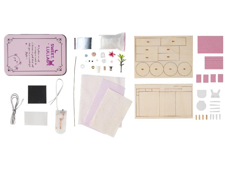 DIY Miniatur-Puppenhaus-Set mit rosa Blechdose, Holzteilen, Stoff und kleinen Accessoires.