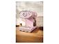 Retro-Kaffeemaschine in Pink mit Manometer, Tassen und Kaffeebohnen auf einer Holztheke.