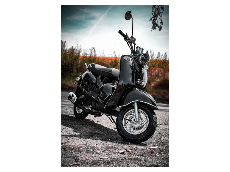 Ein schwarzer Retro-Roller auf einem Schotterweg.