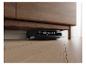 Ein Saugroboter reinigt unter einem Holzschrank auf einem hellen Holzfußboden.