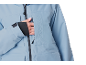 Nahaufnahme einer Frau, die ihre Hand in die Brusttasche einer hellblauen Skijacke steckt.