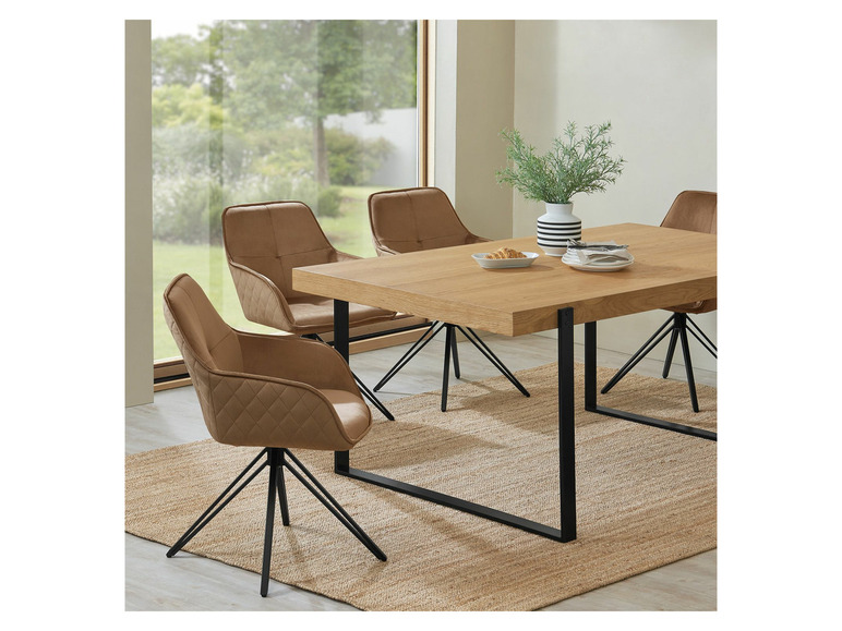 Ein Esstisch aus Holz mit vier Stühlen mit gepolsterten Sitzen