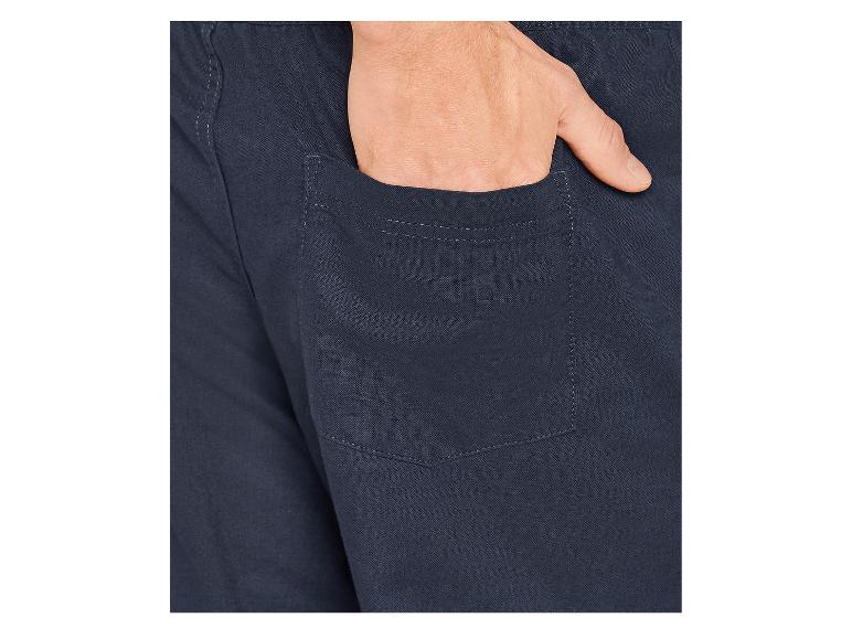 Nahaufnahme einer Hand in der Tasche einer dunkelblauen Hose.