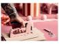 LIVARNO® R53 Handtacker in Pink, gehalten von einer tätowierten Hand, mit Klammern daneben.