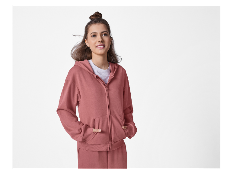 Frau in einem rosa Kapuzenpullover und Hose.