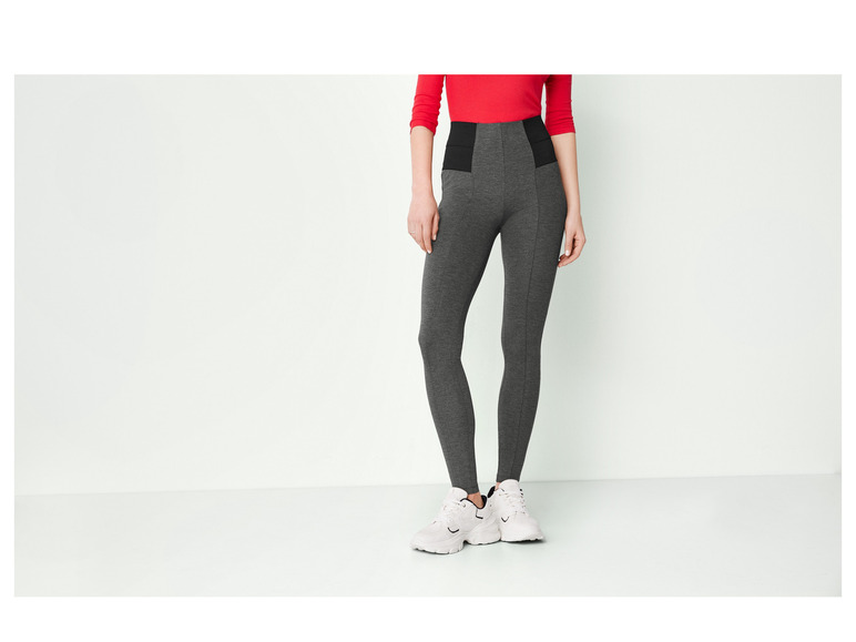 Dunkelgraue Leggings mit hohem Bund und weiße Sneaker.
