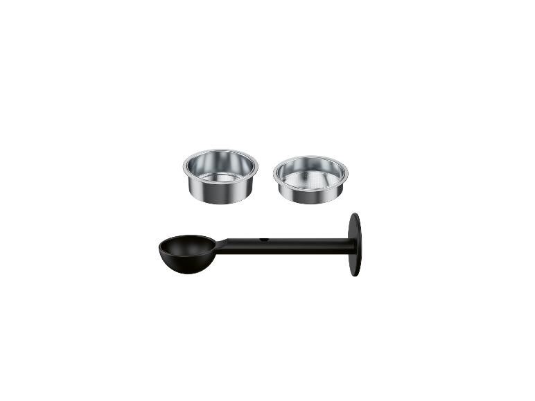 Zwei Kaffeemaschinenfilter und ein schwarzer Messlöffel.